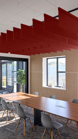 Red straight acoustic blade baffles suspended from ceiling in modern office conference room with wooden table and chairs.