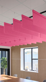 Pink straight acoustic baffles suspended from ceiling in staggered arrangement above wooden slat wall.