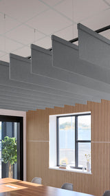 Gray fabric acoustic baffles suspended from ceiling above wooden slat wall paneling in office space.