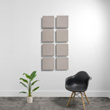 Eight square acoustic panels with textured light gray fabric surfaces arranged in a 2x4 grid on white wall.