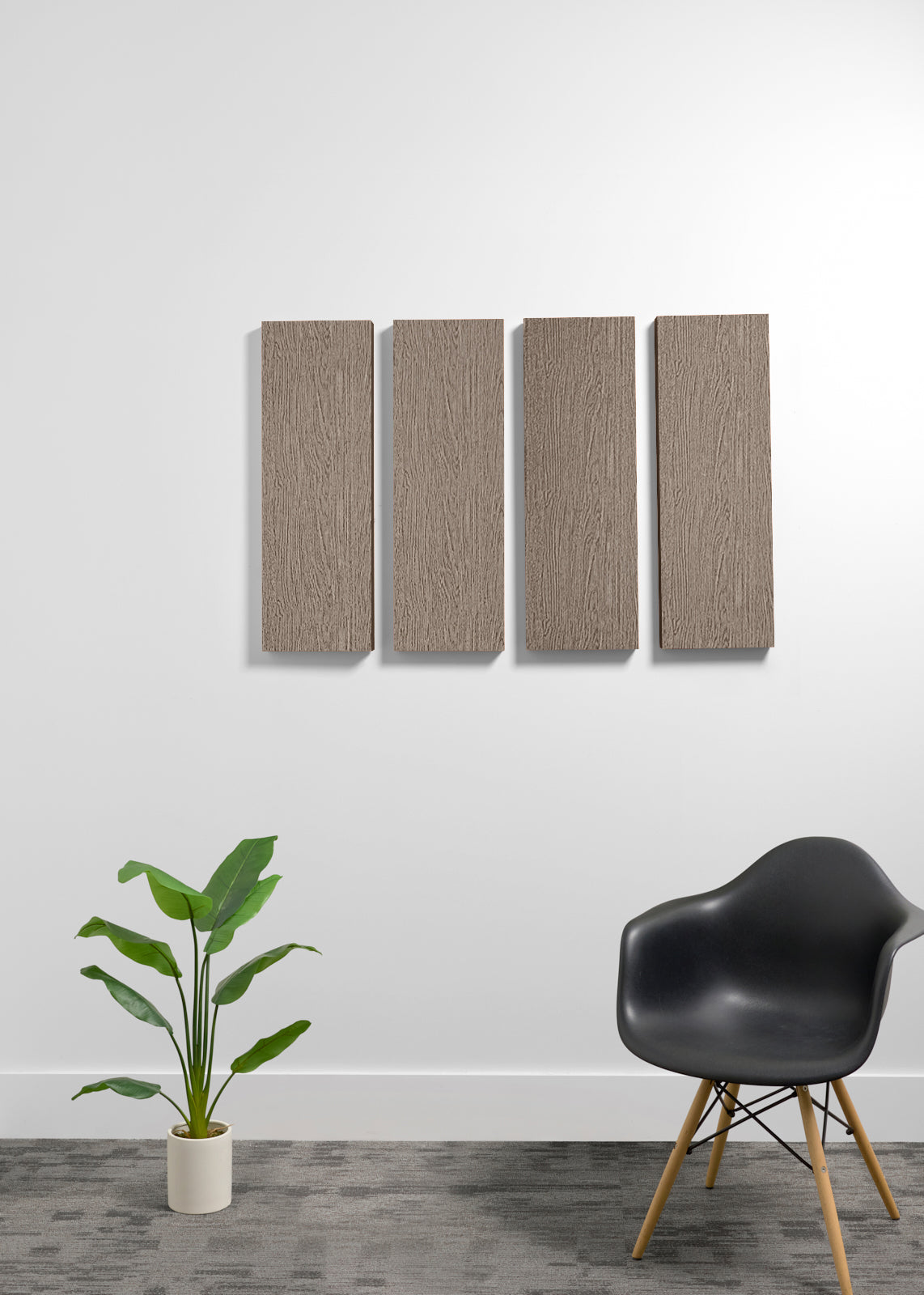 Four rectangular wall panels with a wood grain finish mounted on a white wall, styled in a modern room setting with a black chair and a potted plant.