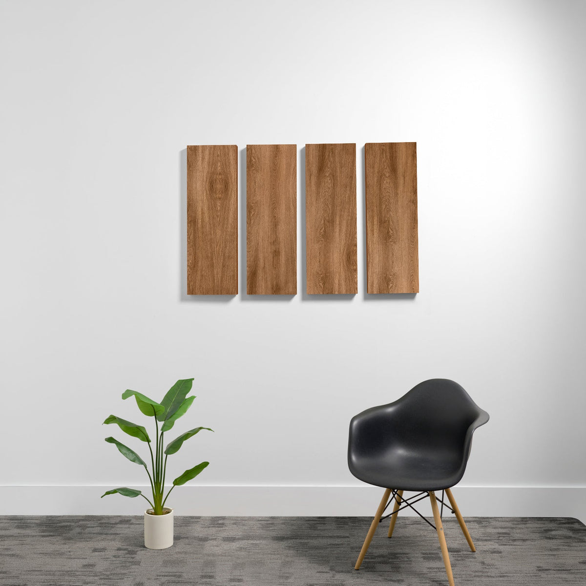 Four rectangular wood-grain acoustic panels mounted on wall above a black chair and potted plant.