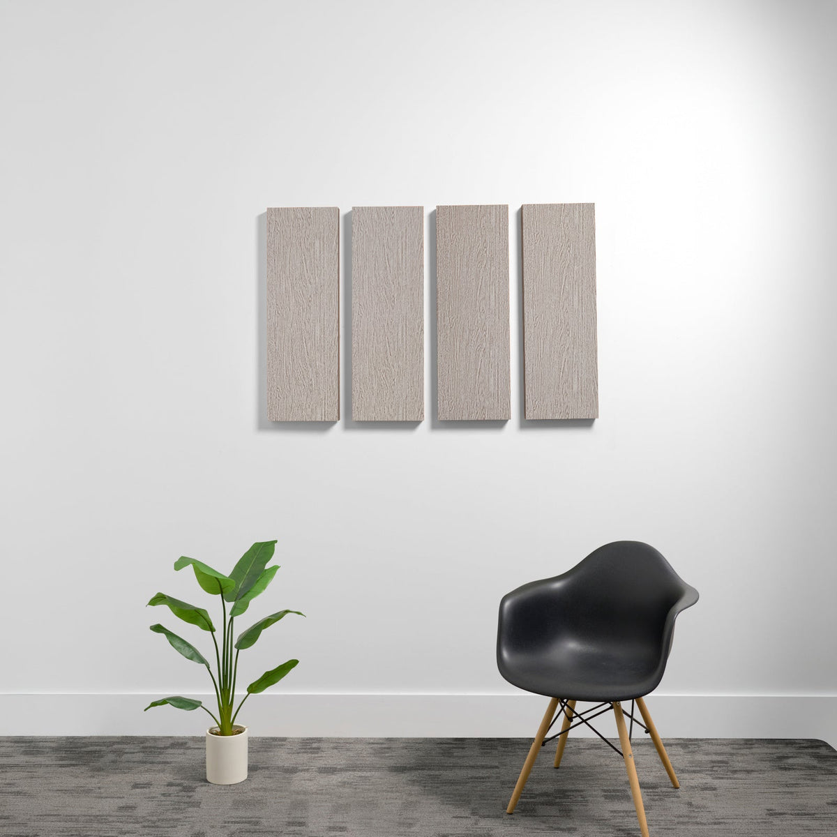 Four rectangular beige acoustic panels mounted vertically on a white wall.