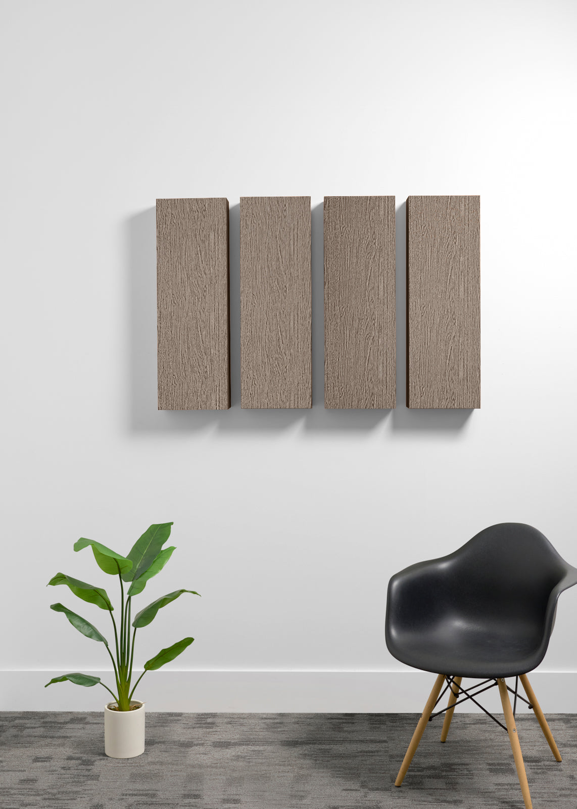 Four rectangular wall panels with a wood grain finish mounted on a white wall, styled in a modern room setting with a black chair and a potted plant.
