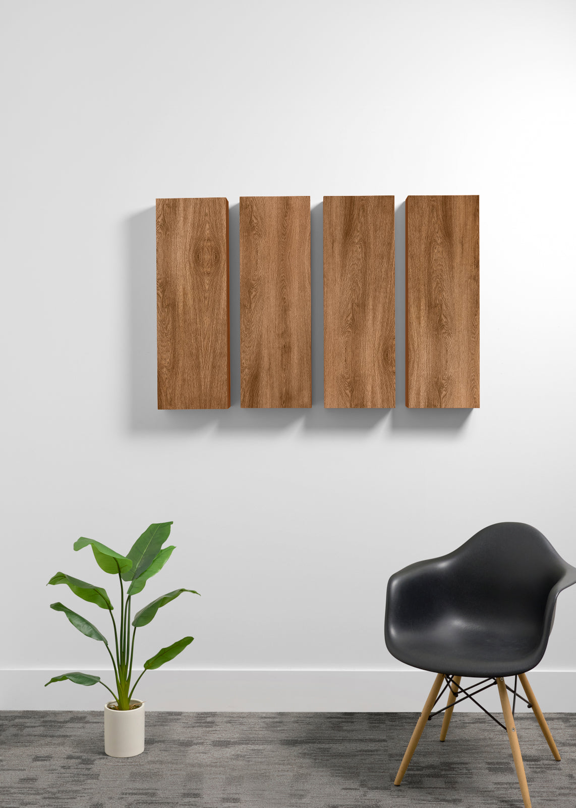 Four rectangular wall panels with a wood grain finish mounted on a white wall, styled in a modern room setting with a black chair and a potted plant.