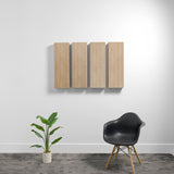 Four rectangular light wood acoustic panels mounted on white wall in a room setting.