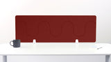 Burgundy desk divider with wavy cutout pattern, mounted on white desk with gray mug and notepad.