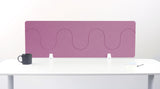 Mauve wave-patterned desk divider with white mounting brackets on white desk surface.