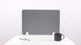 Gray felt desk divider with white mounting brackets on white desk surface.