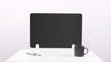 Dark gray fabric desk divider with white base supports positioned on white desk surface.