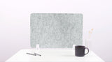 Gray felt board on a white surface with a black mug and pen.