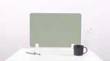 Sage green desk divider with rounded corners positioned on white desk with mounting brackets.