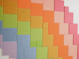 Felt Right wall art design using pixel square tiles in shades of the rainbow to create a pixel look of the rainbow.