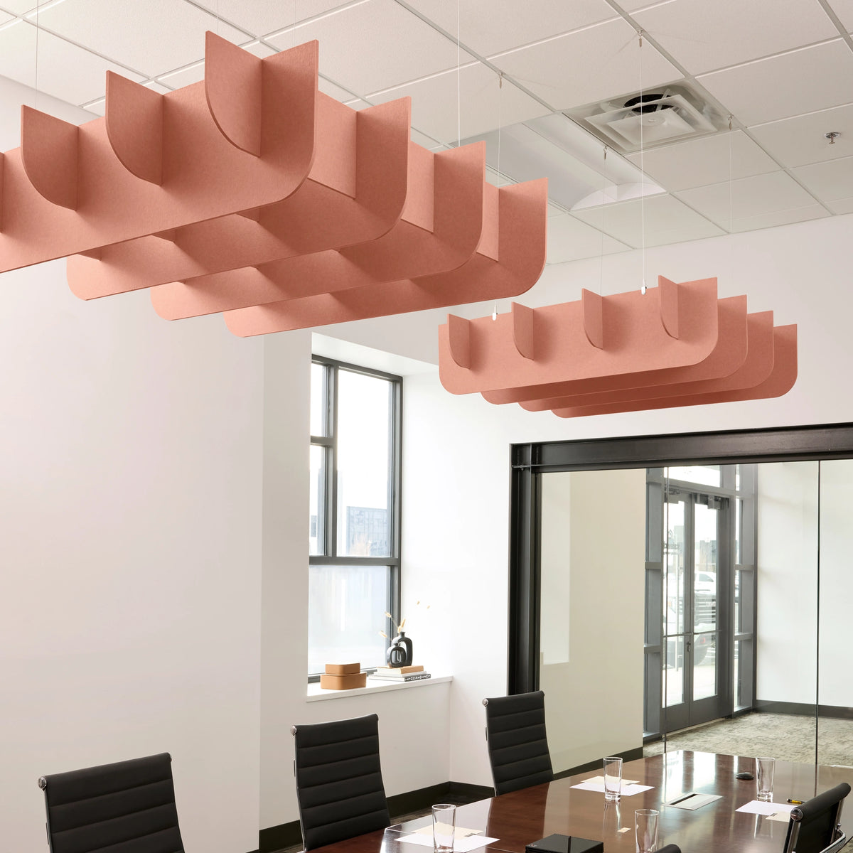 Fin 3D Cloud acoustic ceiling baffles in Coral felt above a conference table