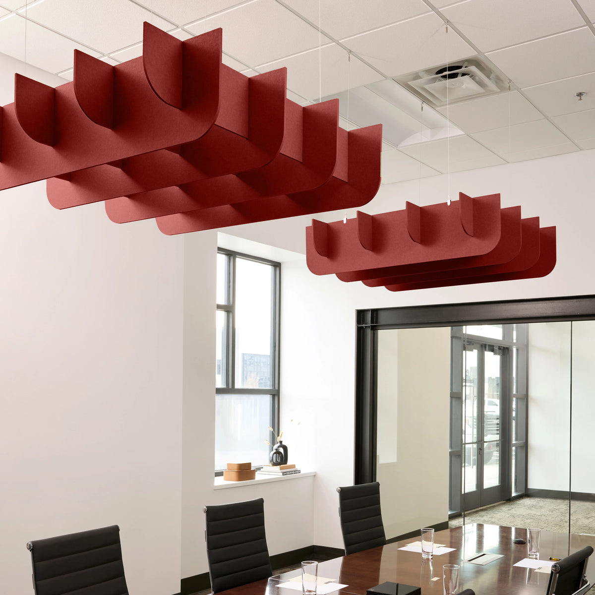 Fin 3D Cloud acoustic ceiling baffles in Crimson felt above a conference table