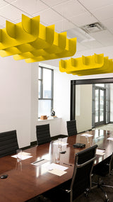 Yellow 3D cloud-shaped acoustic baffles suspended from ceiling above conference table.