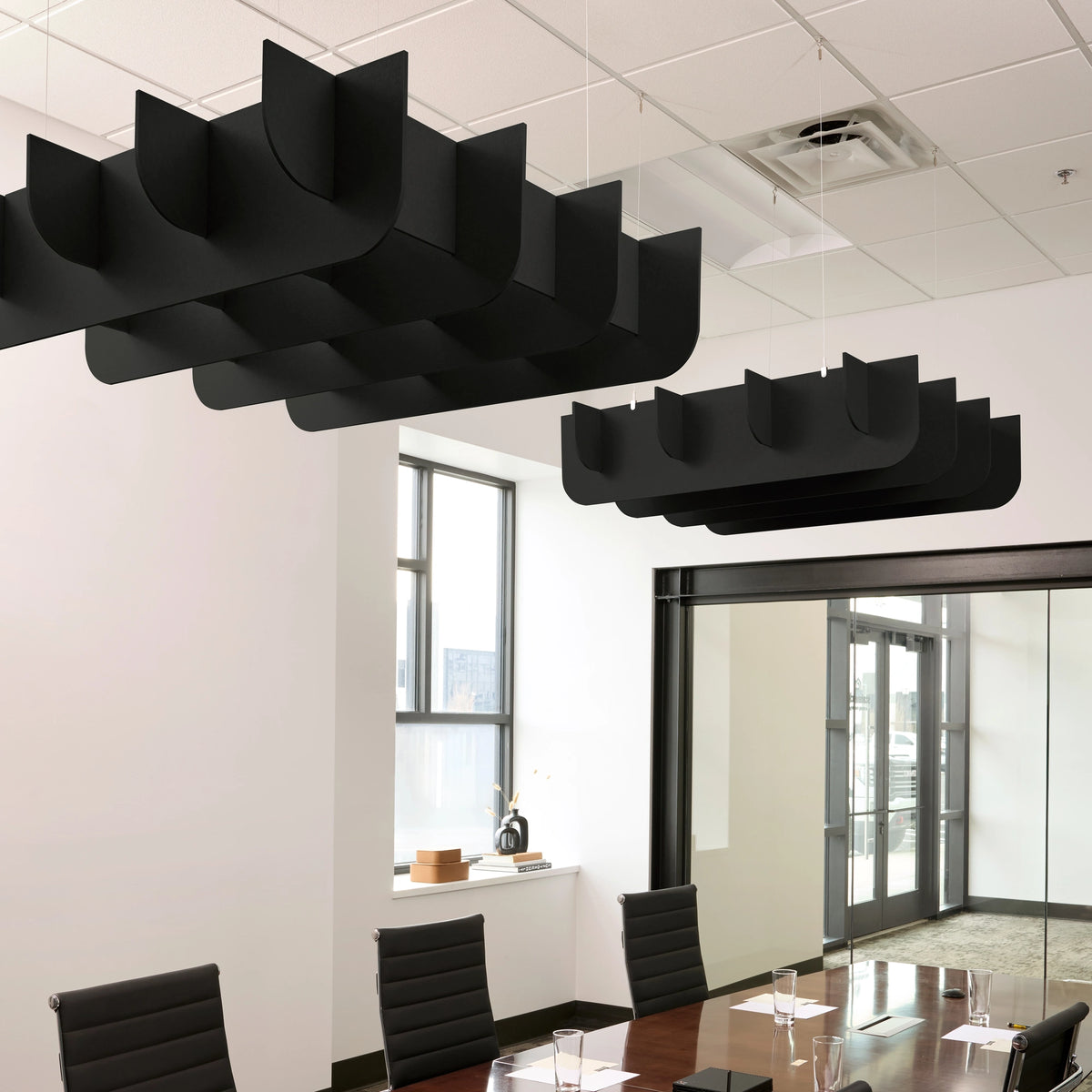 Fin 3D Cloud acoustic ceiling baffles in Ebony felt above a conference table
