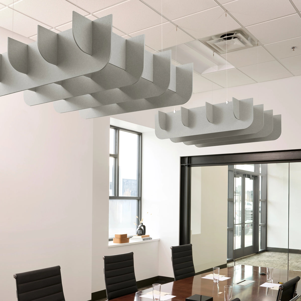 Fin 3D Cloud acoustic ceiling baffles in Fog felt above a conference table