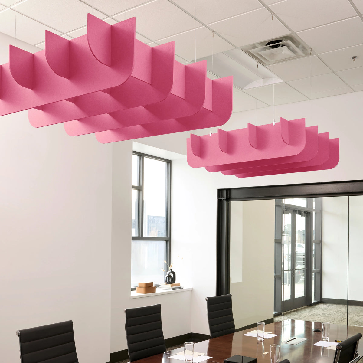Fin 3D Cloud acoustic ceiling baffles in Hot Pink felt above a conference table