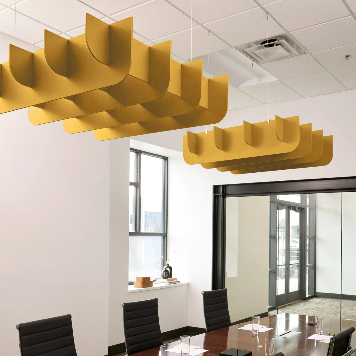 Fin 3D Cloud acoustic ceiling baffles in Mustard felt above a conference table