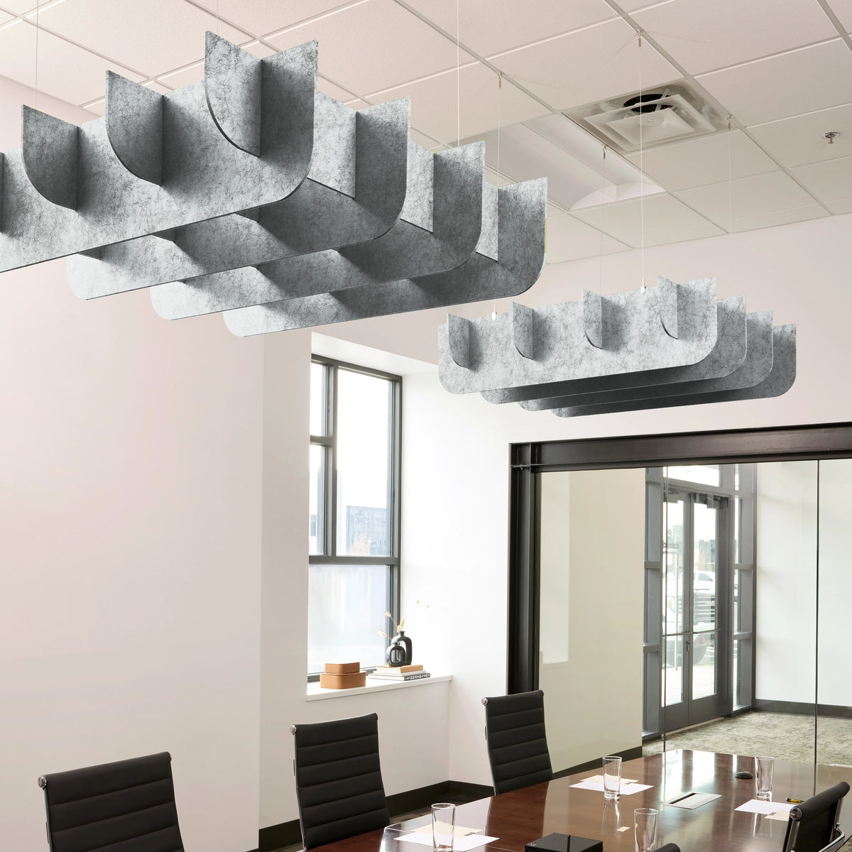 Fin 3D Cloud acoustic ceiling baffles in Nickel felt above a conference table
