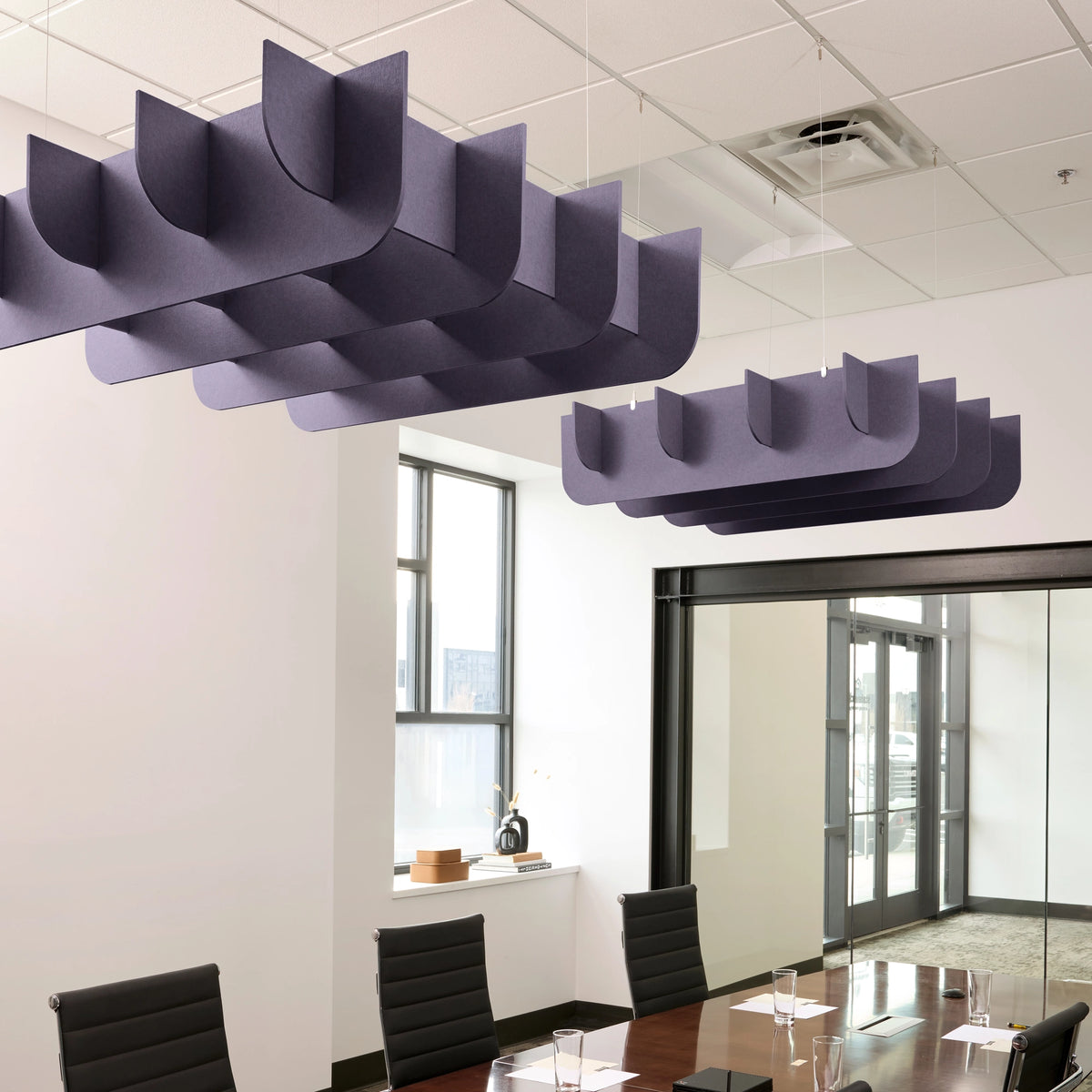 Fin 3D Cloud acoustic ceiling baffles in Wisteria felt above a conference table