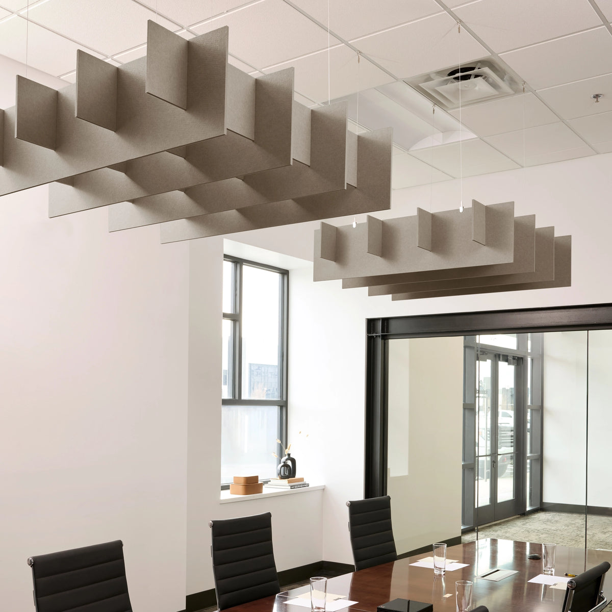 Grid 3D Cloud acoustic ceiling baffles in Ash felt above a conference table