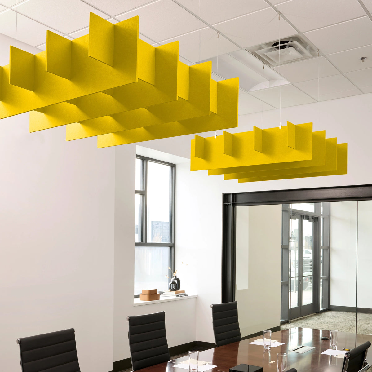 Grid 3D Cloud acoustic ceiling baffles in Dandelion felt above a conference table