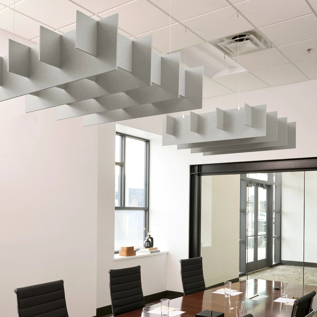 Grid 3D Cloud acoustic ceiling baffles in Fog felt above a conference table