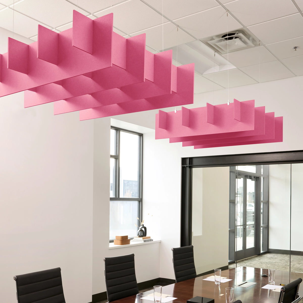 Grid 3D Cloud acoustic ceiling baffles in Hot Pink felt above a conference table