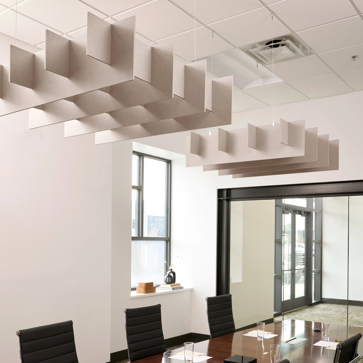 Grid 3D Cloud acoustic ceiling baffles in Latte felt above a conference table