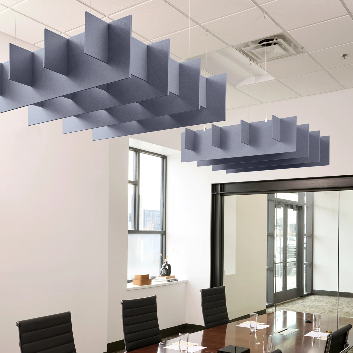 Grid 3D Cloud acoustic ceiling baffles in Periwinkle felt above a conference table
