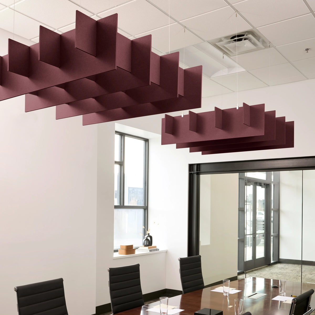 Grid 3D Cloud acoustic ceiling baffles in Wine felt above a conference table