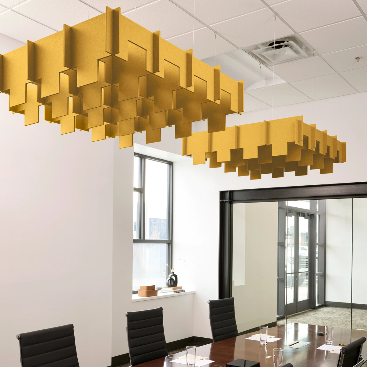 Drop 3D Cloud acoustic ceiling baffles in Mustard felt above a conference table