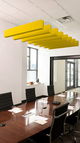 Multiple yellow acoustic ceiling beams suspended above a conference table in an office setting.