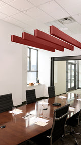 Red felt acoustic beams suspended from ceiling in conference room above wooden table with black chairs.