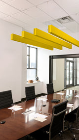 Four yellow acoustic beams suspended from ceiling above conference table in office meeting room.
