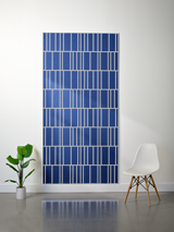 Blue felt sheet with offset engraved linear pattern in white, displayed on wall.