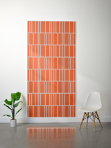 Orange felt sheet with white engraved offset rectangular grid pattern displayed on wall.