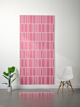 Pink felt sheet with white engraved rectangular pattern in offset rows displayed on wall.