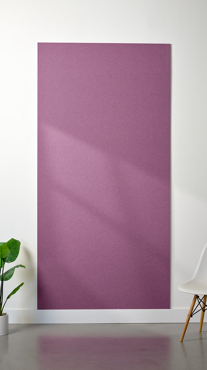 Purple Felt Right 4’ x 8’ PET felt panel with no engraving against a white wall. A plant and chair are in the foreground.
