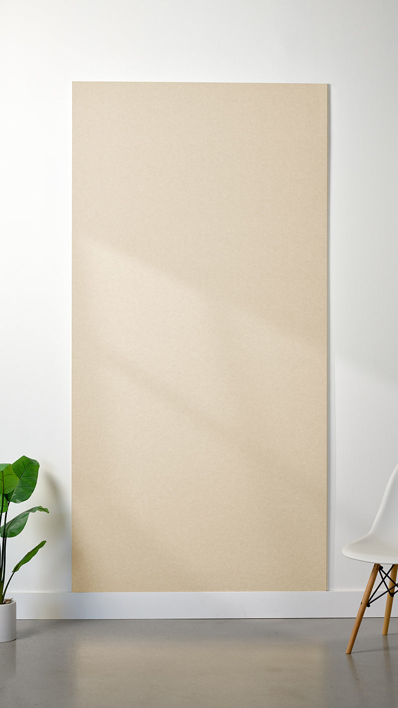 Beige Felt Right 4’ x 8’ PET felt panel with no engraving against a white wall. A plant and chair are in the foreground.