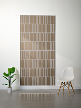 Tan and white layered felt sheet with offset engraved vertical stripe pattern displayed on wall.