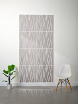 Layered gray felt sheet with engraved wavy linear pattern in four sections, mounted on white wall.