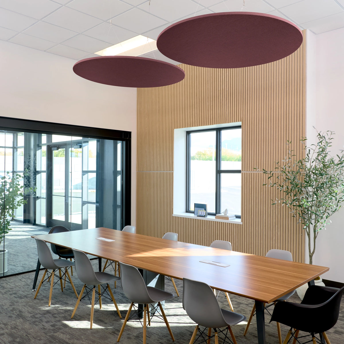 Circle Flat Cloud acoustic ceiling baffles in Wine felt above a conference table
