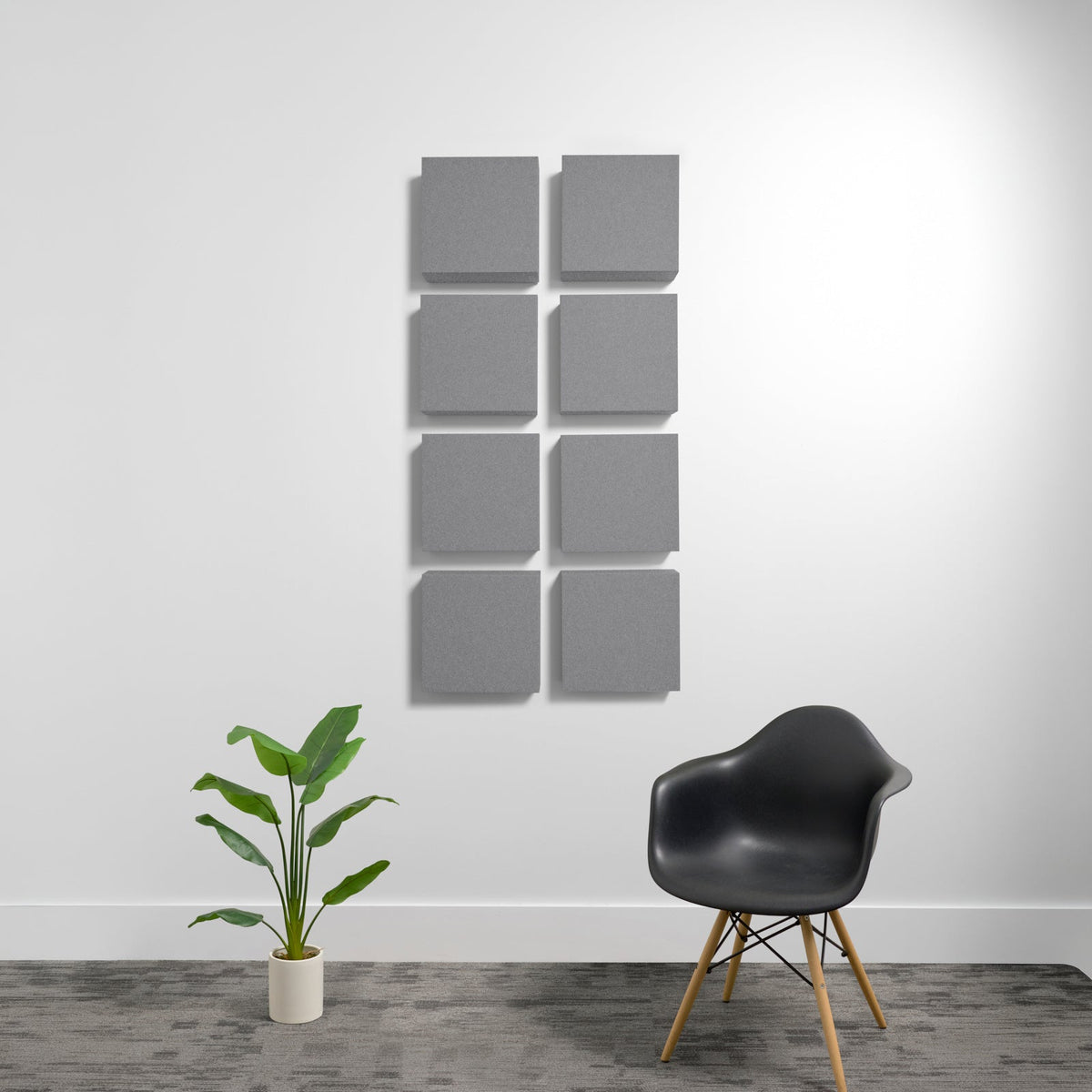 Eight gray square acoustic panels arranged in two columns on a white wall.