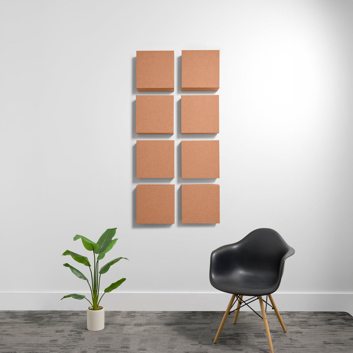 Eight tan square acoustic panels mounted in two columns on white wall.