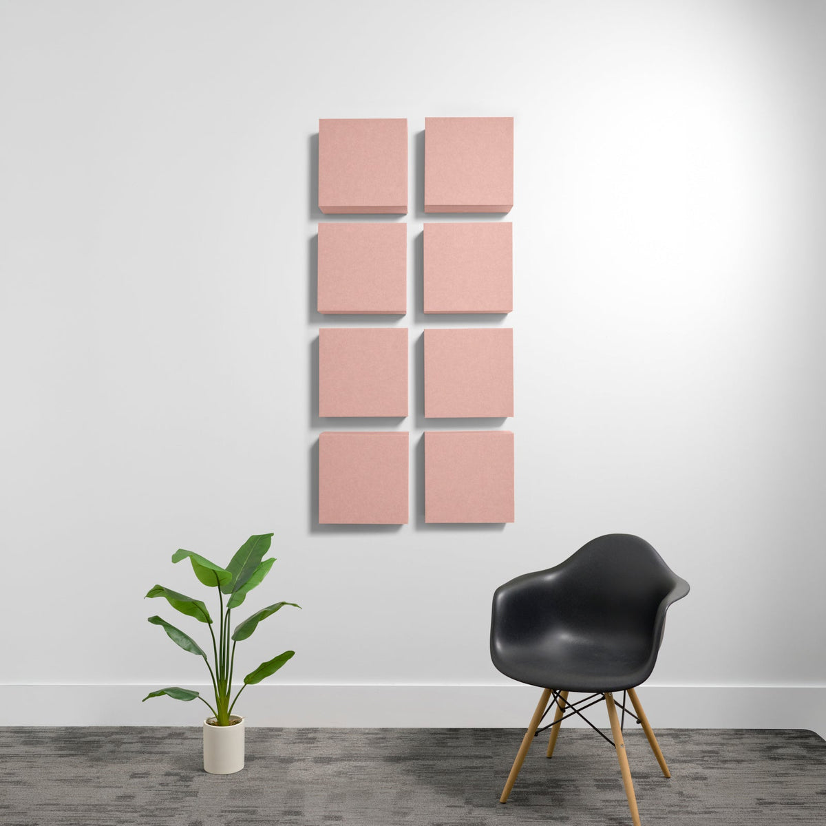 Eight pink square acoustic panels arranged in a 2x4 grid on a white wall.
