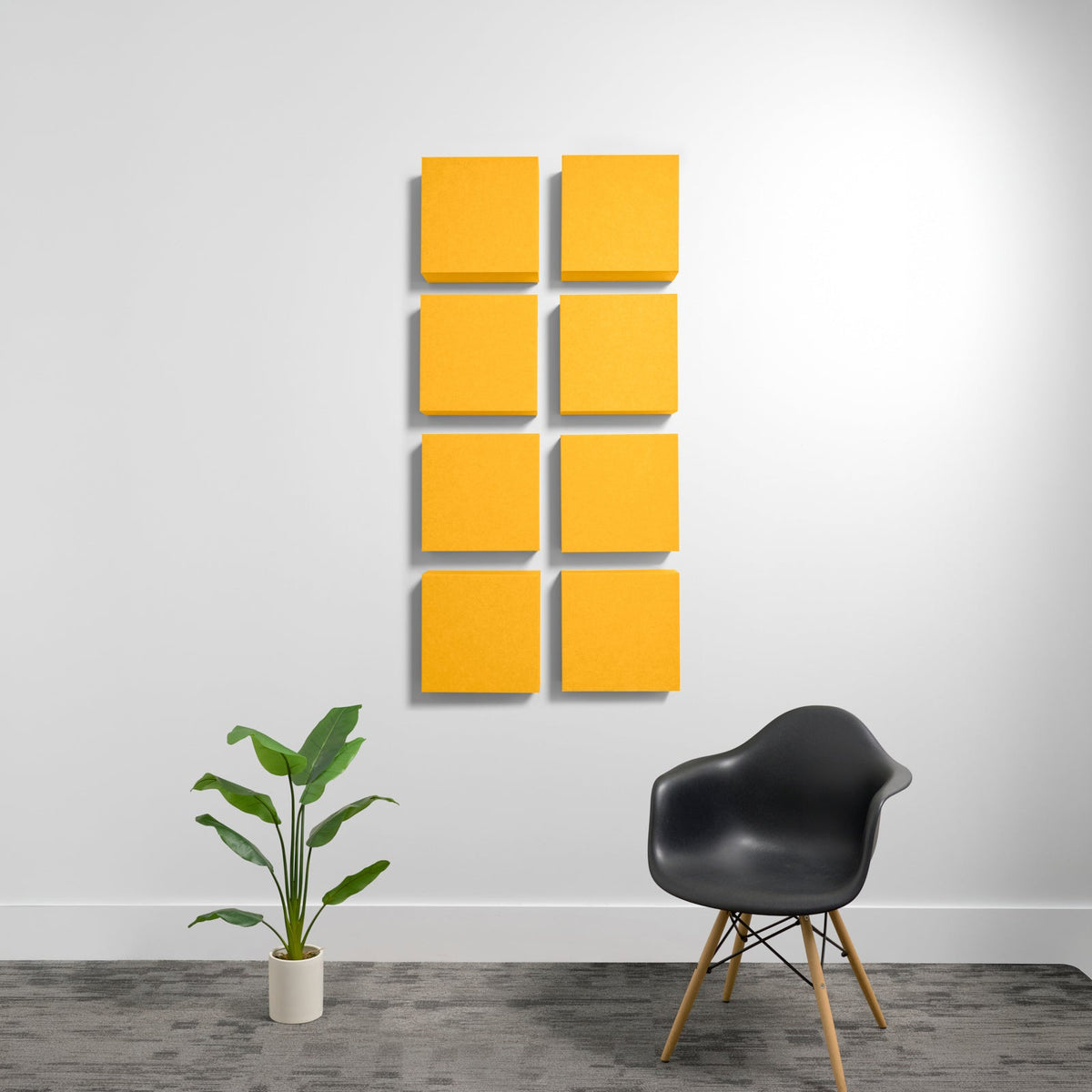 Eight yellow square acoustic panels arranged in a 2x4 grid on white wall with shadow depth.