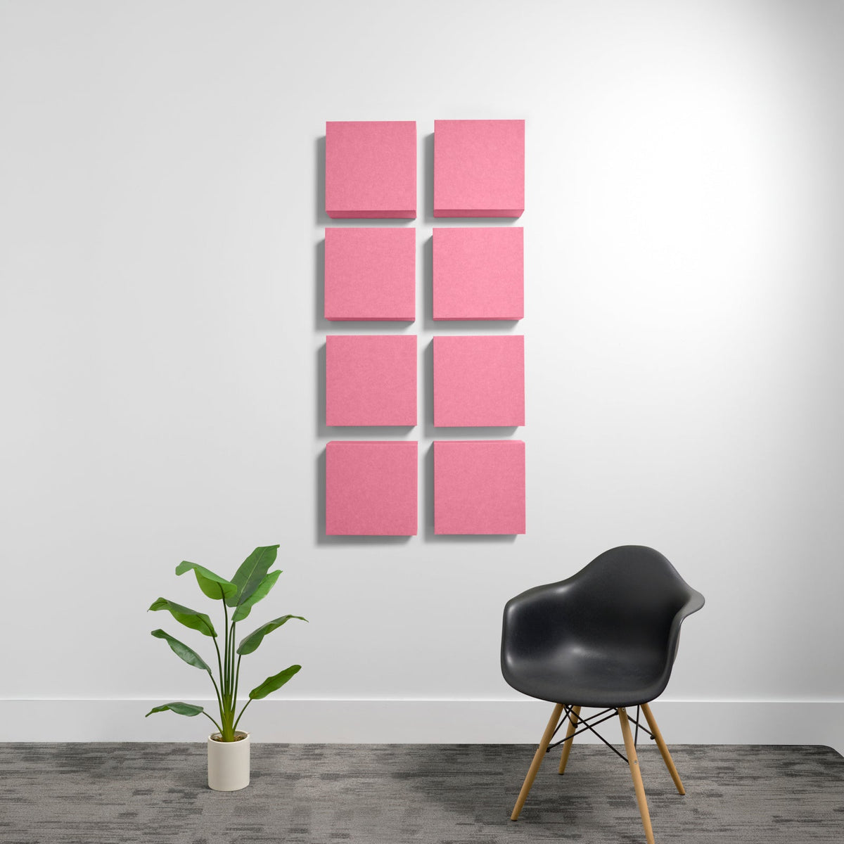 Eight pink square acoustic panels arranged in a 2x4 grid on a white wall.